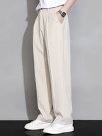 Pantalón recto relajado beige claro, pliegues sutiles en la cintura y caída amplia.