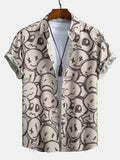 Camisa de manga corta color arena con estampado de caritas y cuello con botones