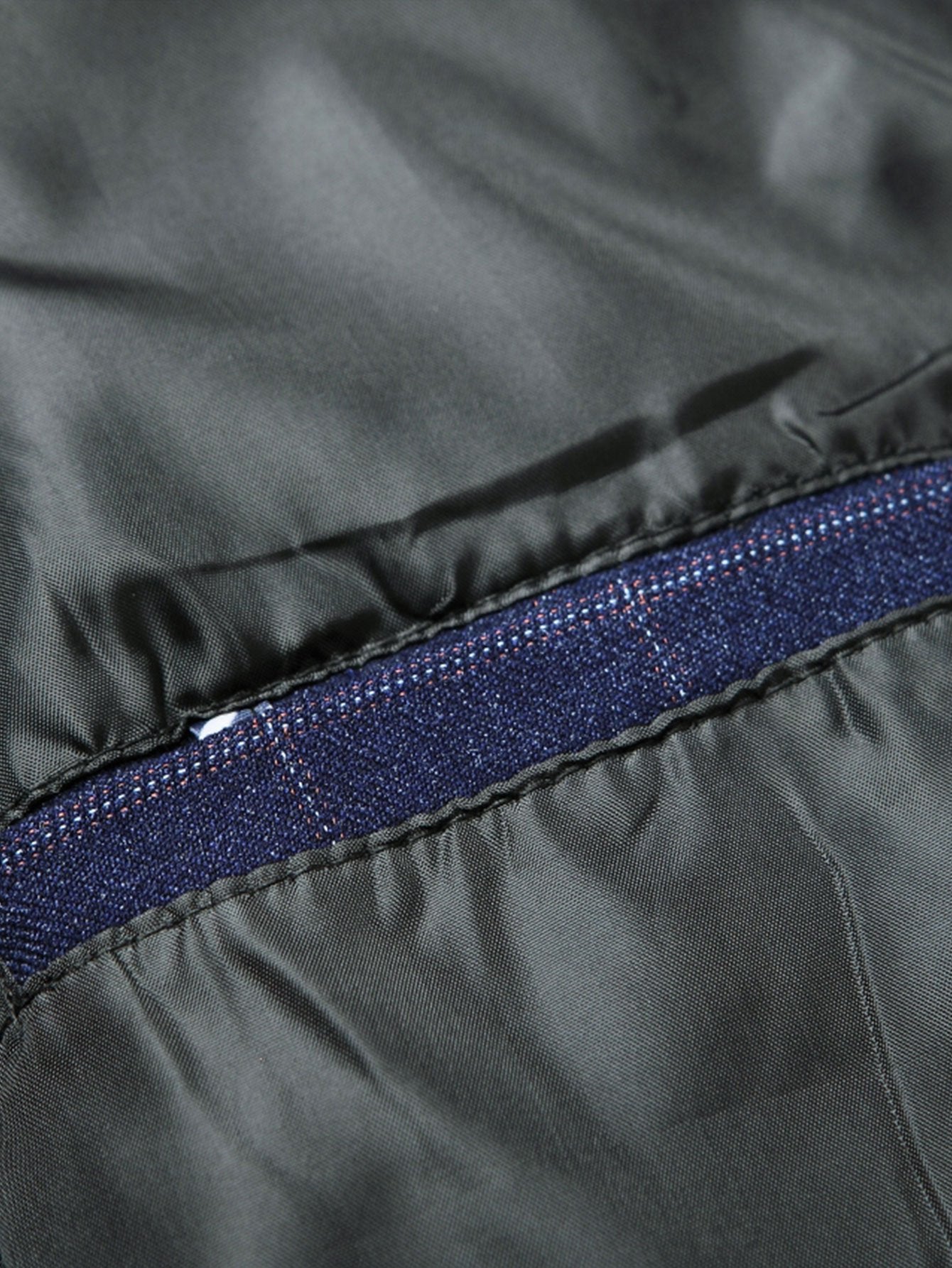 Forro interior del blazer con ribete en tela azul marino y costura visible