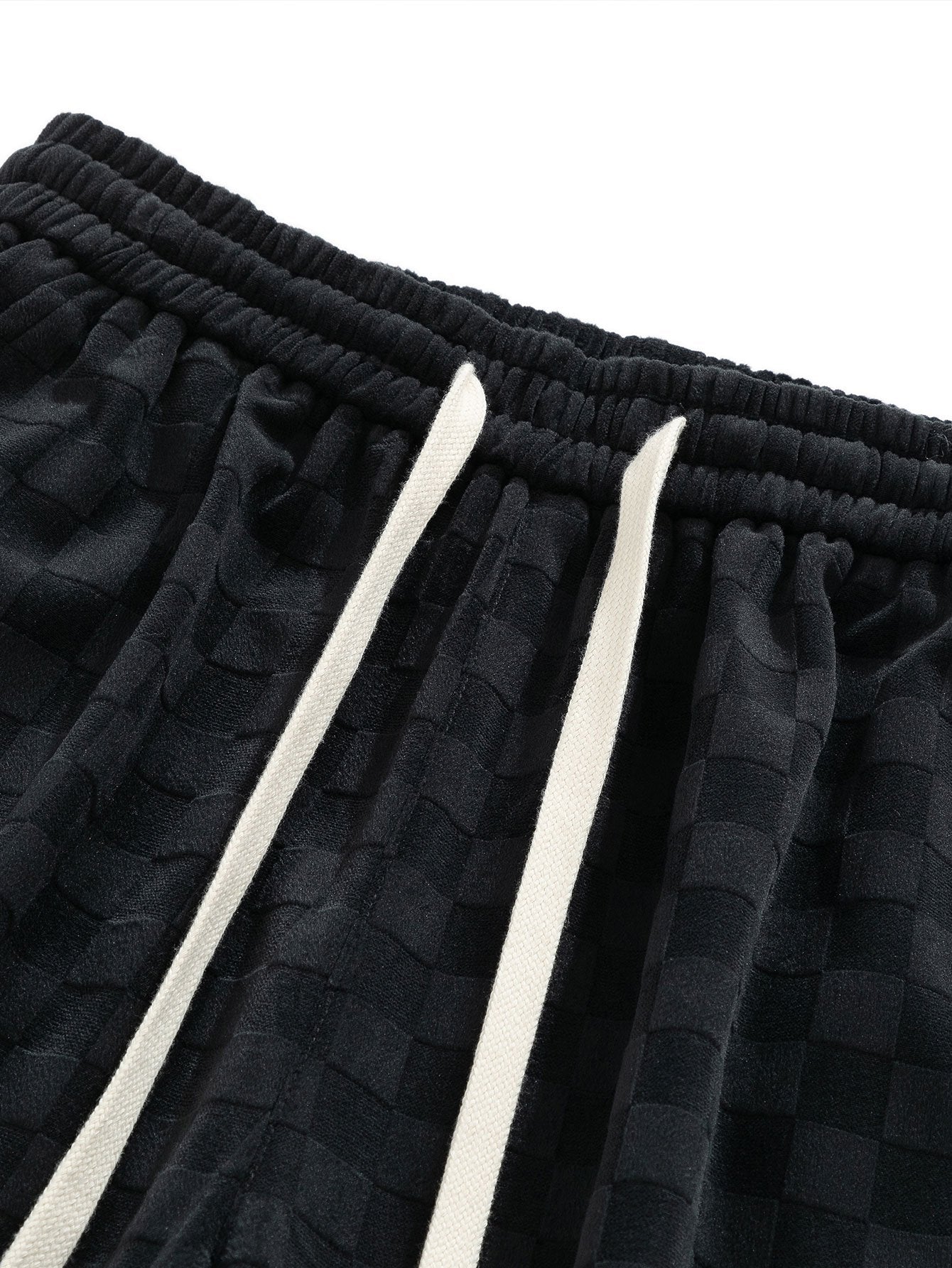 Cintura elástica con cordones blancos y patrón texturizado del pantalón