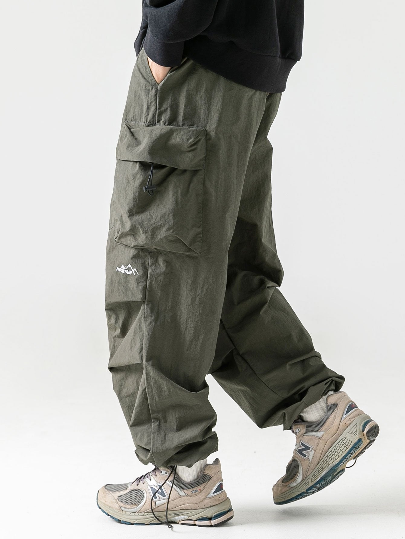 Pantalón paracaídas verde oscuro con bolsillos cargo y rodillas abullonadas
