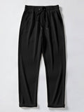 Pantalón recto de canalé negro, cintura elástica con cordón y bajo con puños.