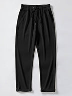 Pantalón recto de canalé negro, cintura elástica con cordón y bajo con puños.