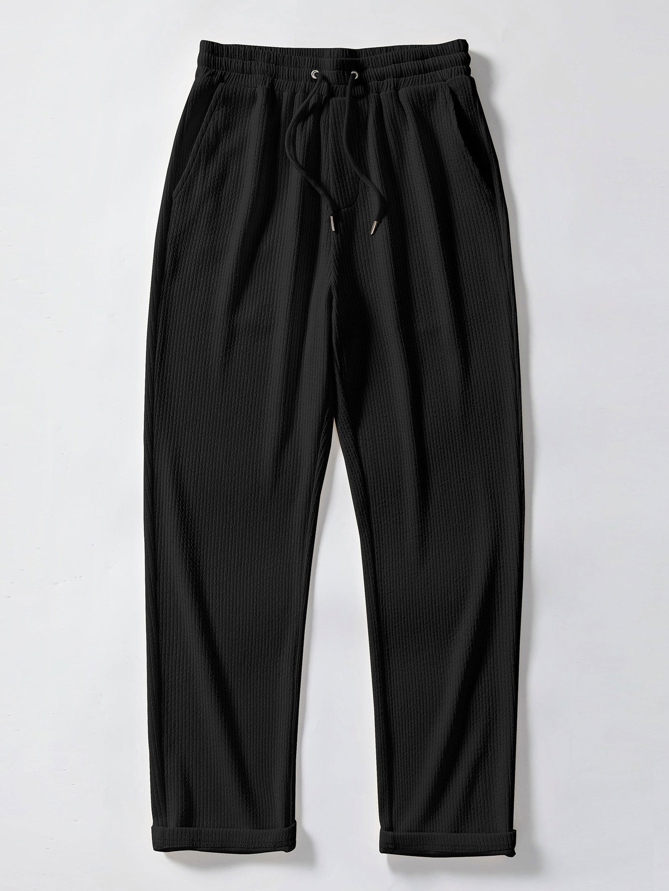 Pantalón recto de canalé negro, cintura elástica con cordón y bajo con puños.