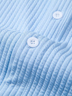 Cuello y parte delantera de camisa azul acanalada con botones