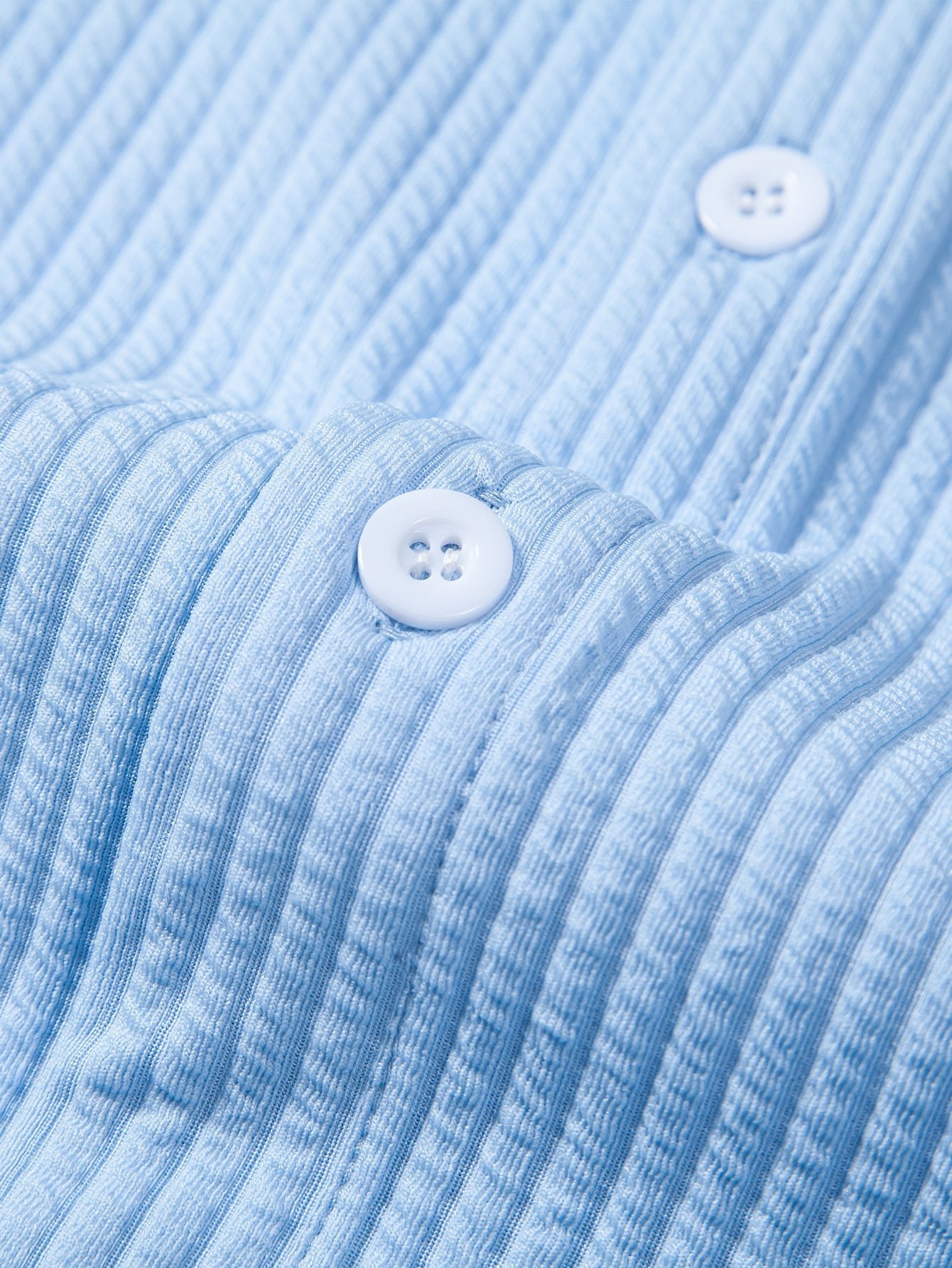 Cuello y parte delantera de camisa azul acanalada con botones