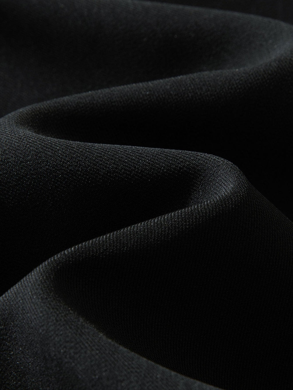 Tela de pantalón recto relajado negro, textura lisa y tejida