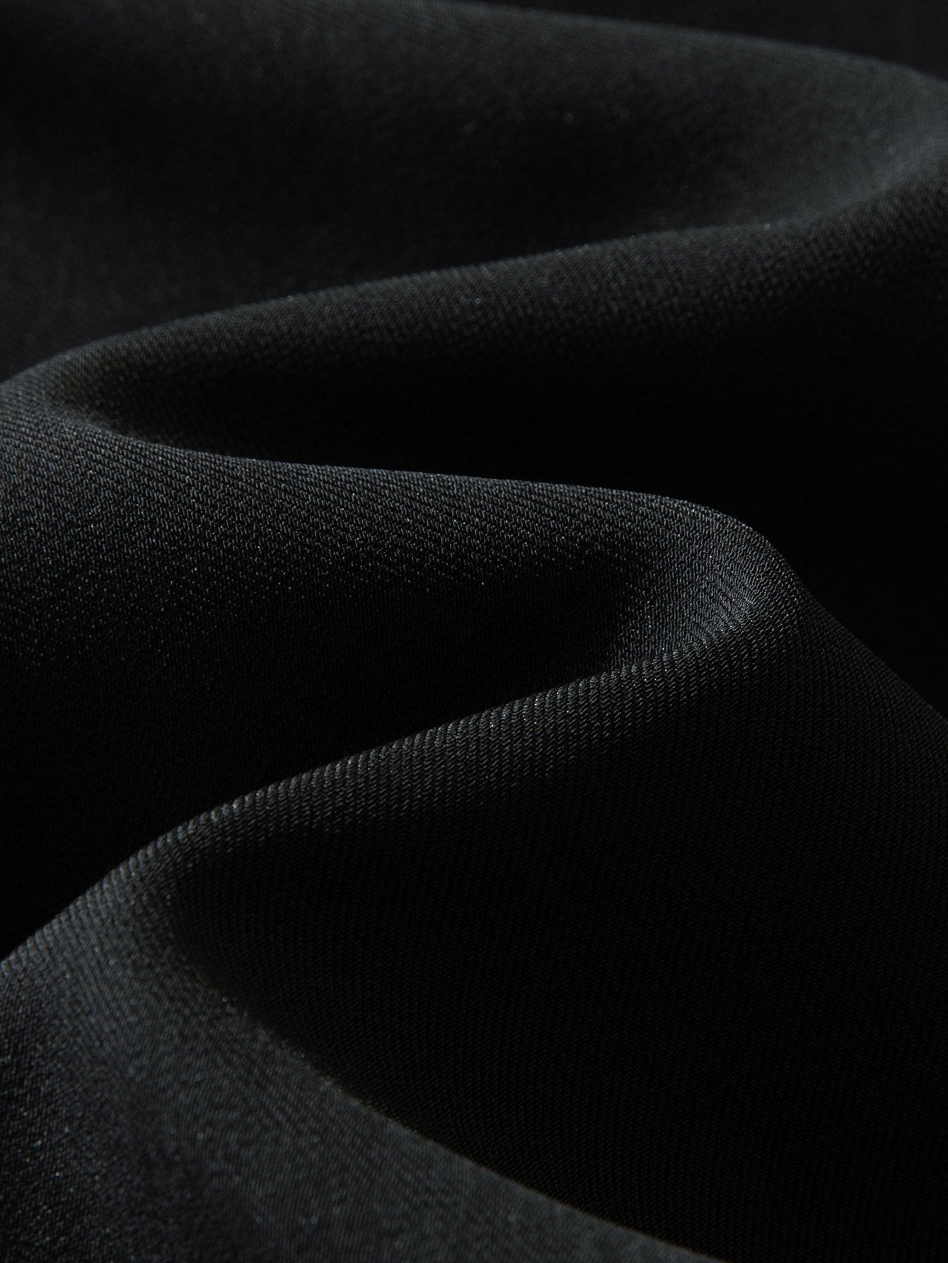 Tela de pantalón recto relajado negro, textura lisa y tejida