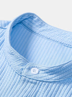 Camisa azul acanalada: cuello redondeado y botones blancos en la tapeta