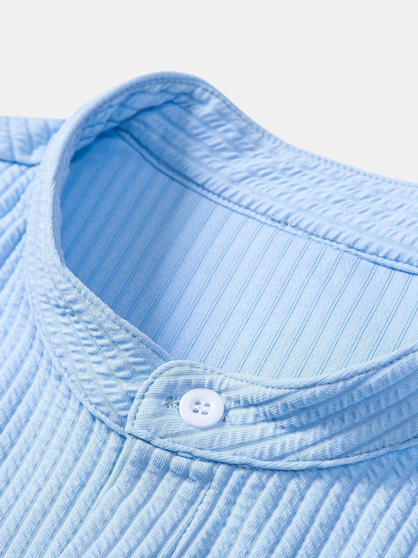 Cuello de pie de camisa celeste acanalada con botón frontal