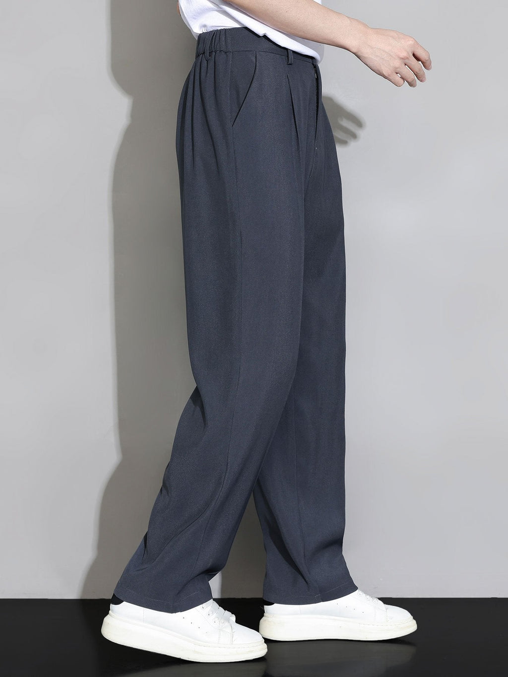 Pantalón recto relajado azul grisáceo oscuro, cintura con elástico y pernera amplia.