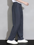 Pantalón recto relajado azul grisáceo oscuro, cintura con elástico y pernera amplia.