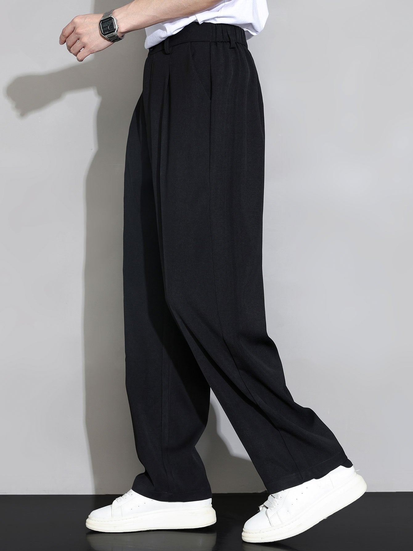 Pantalón recto relajado negro con pierna amplia y costuras visibles; bolsillos laterales.