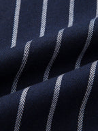 Tela de camisa azul marino con rayas claras verticales en textura tejida.