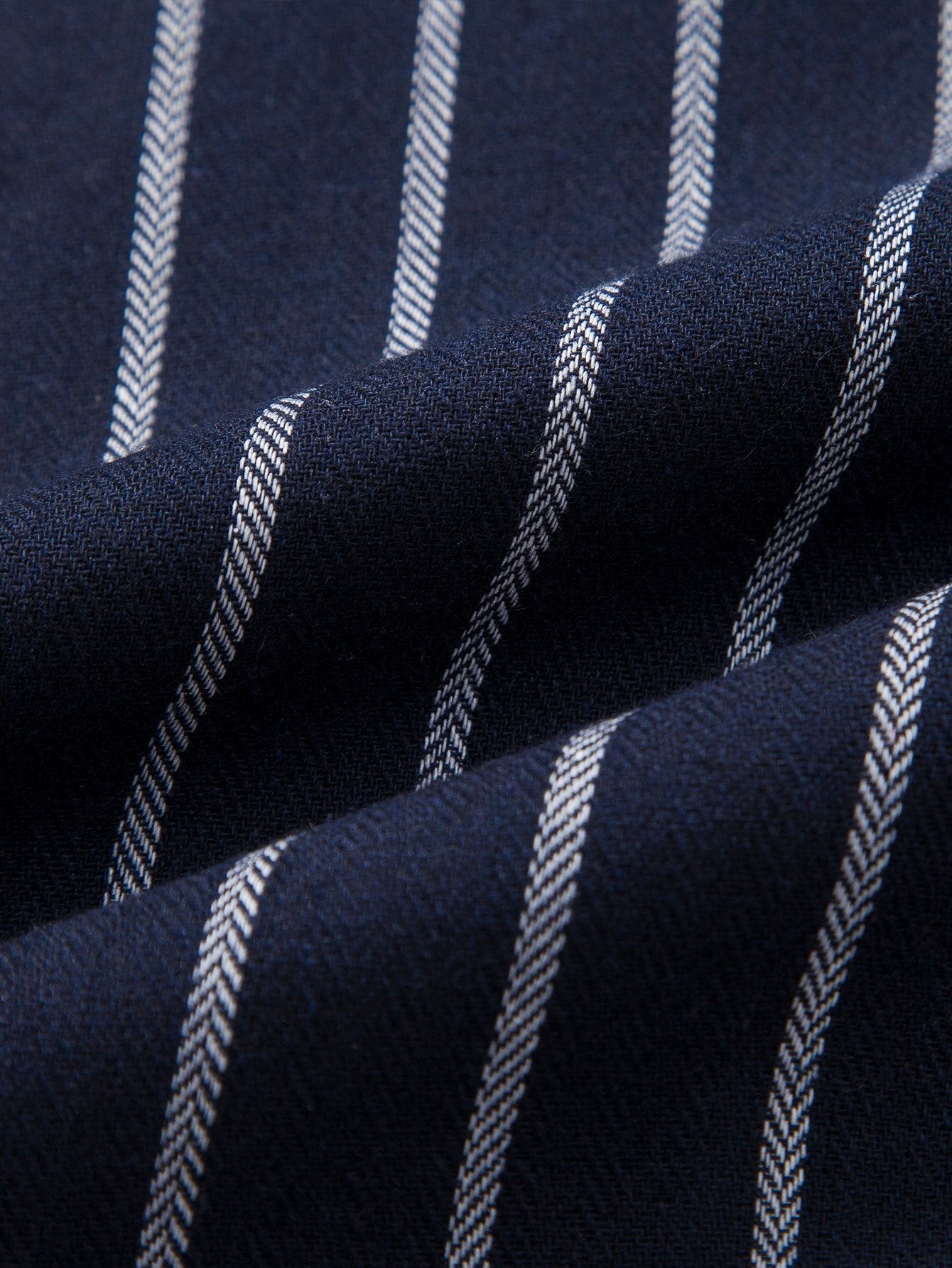 Tela de camisa azul marino con rayas claras verticales en textura tejida.