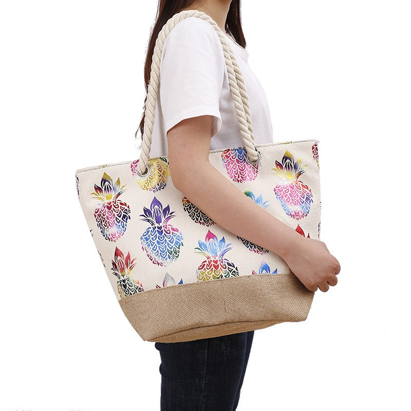 Bolso tote con estampado multicolor de piñas, asas trenzadas y tela tipo yute beige