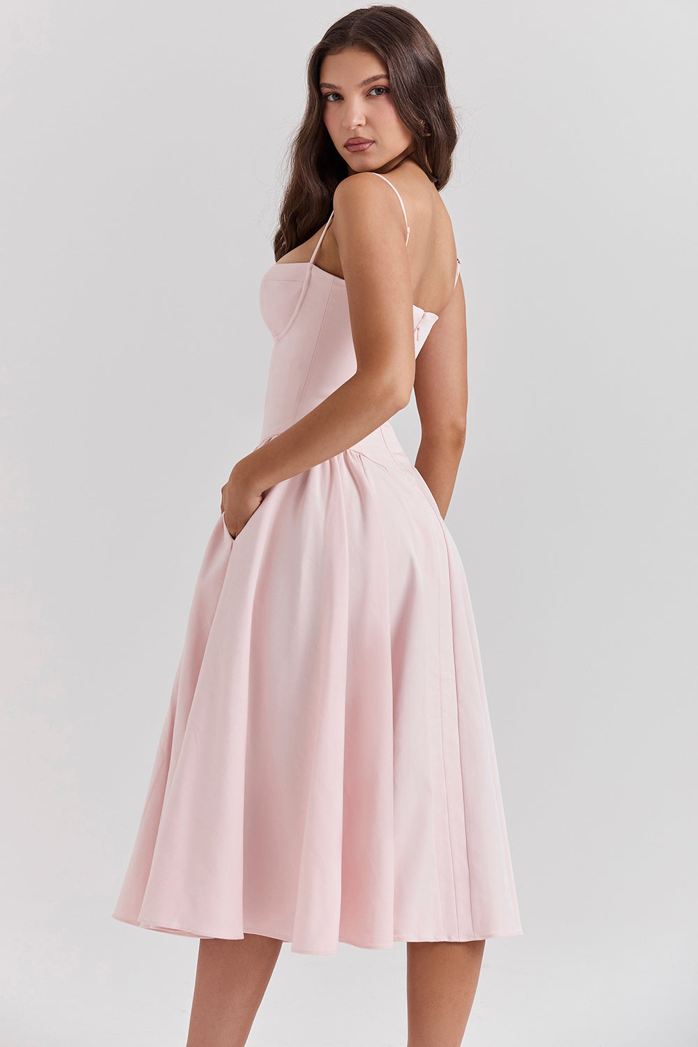 Vestido midi rosa con tirantes finos y falda acampanada con pliegues suaves