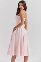 Vestido midi rosa con tirantes finos y falda acampanada con pliegues suaves
