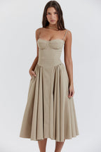 Vestido NOVA crema sin tirantes, escote corazón, falda con tablas hasta la rodilla.
