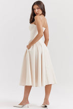 Vestido midi crema sin mangas con tirantes finos, cuerpo entallado y falda acampanada