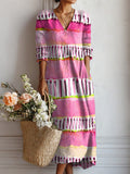 Vestido largo bohemio multicolor con rayas rosas, moradas y grises, escote en V y mangas abullonadas